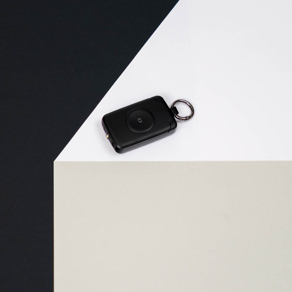 Black PTC WatchGo 2000 power bank with keyring on a black and white backdrop
