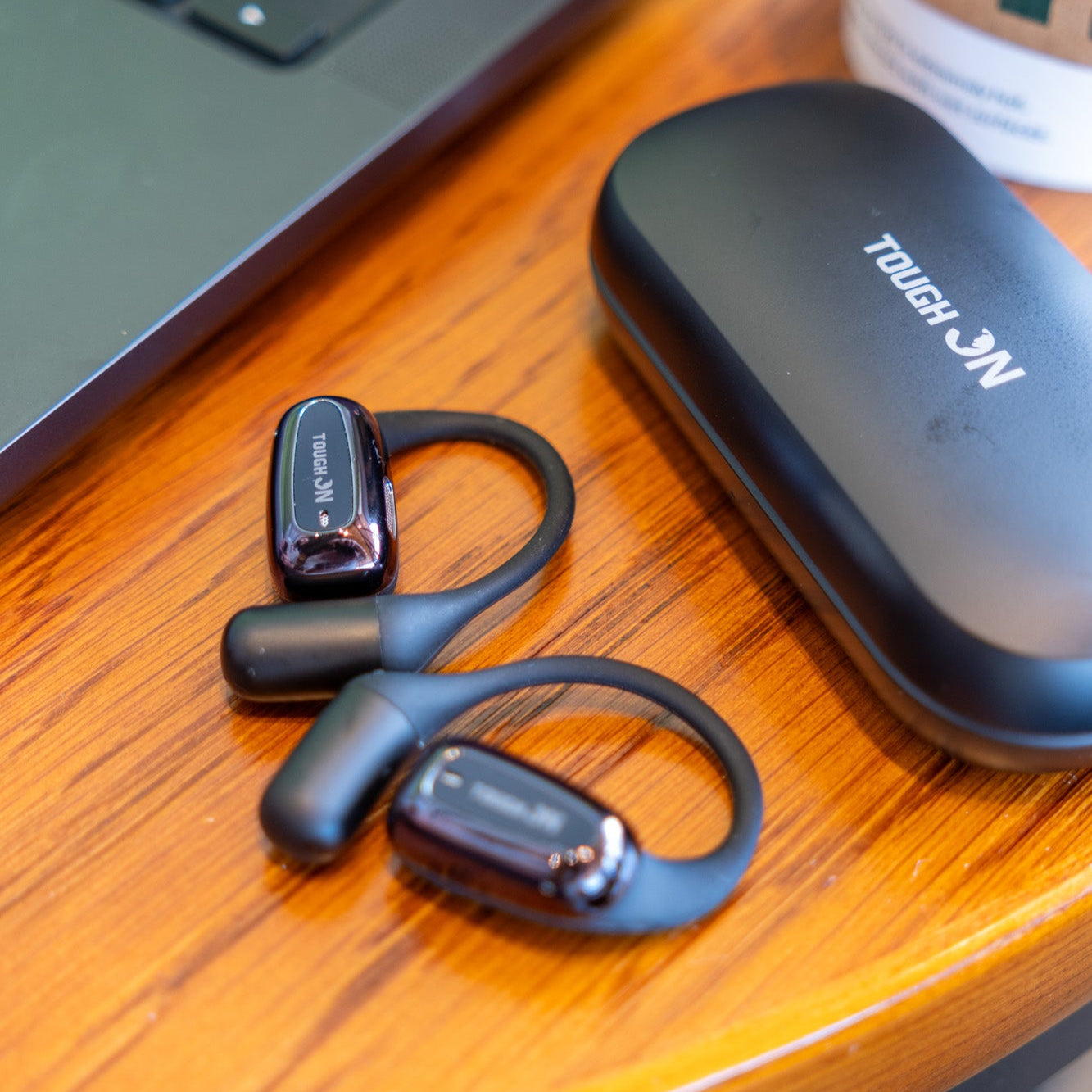 Wireless earbuds with charging case on a wooden desk