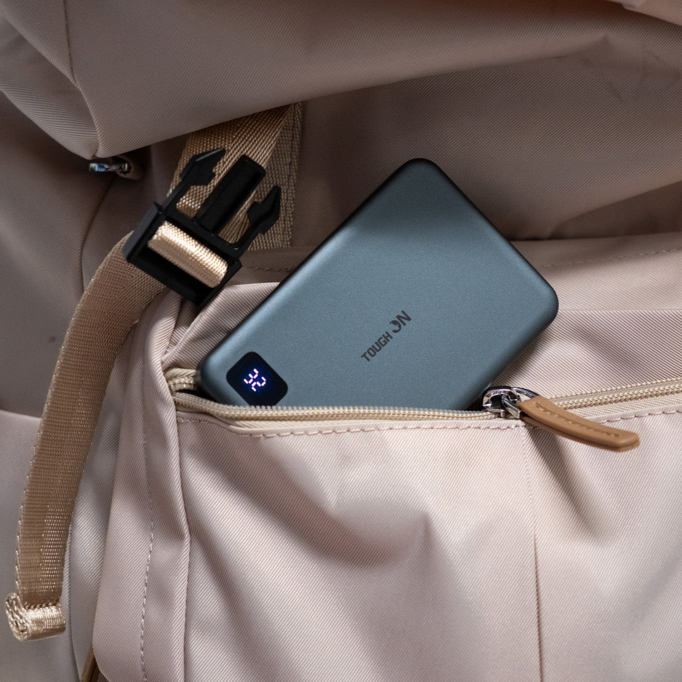 Slim power bank with a visible brand logo in an open beige bag