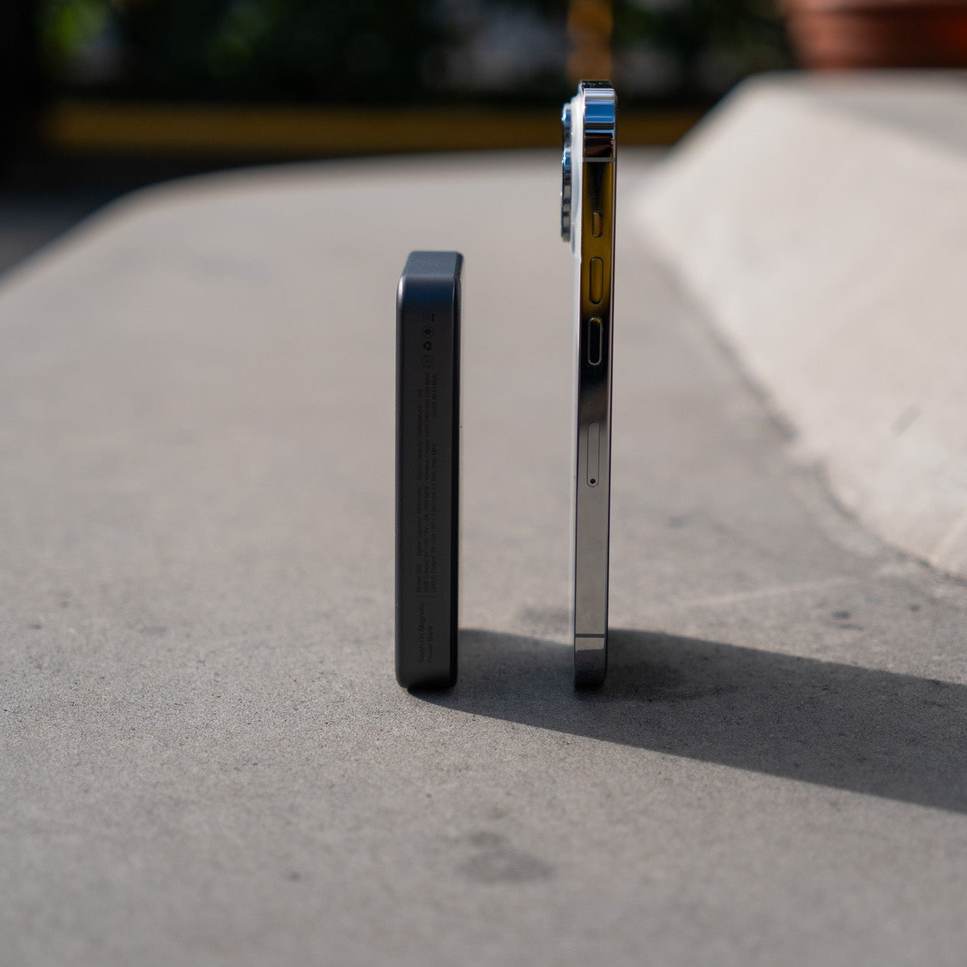 Two metal devices on a concrete surface with a blurred background