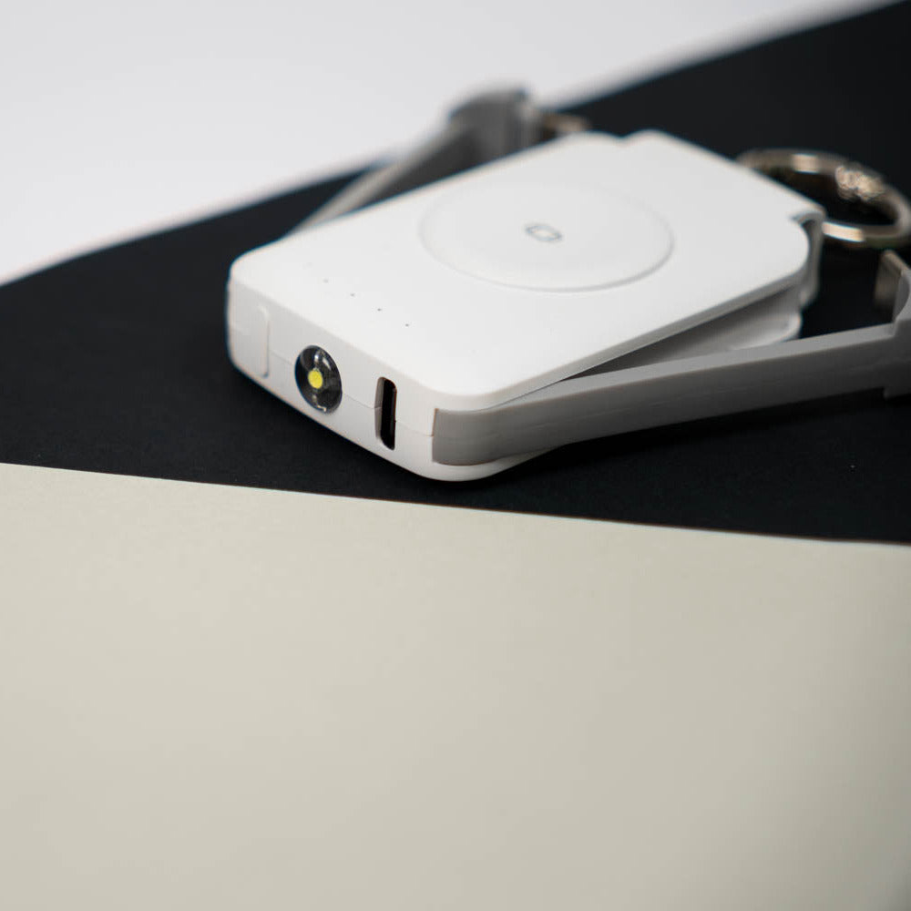 Close-up of the white PTC WatchGo 2000 showing its built-in LED light and charging port