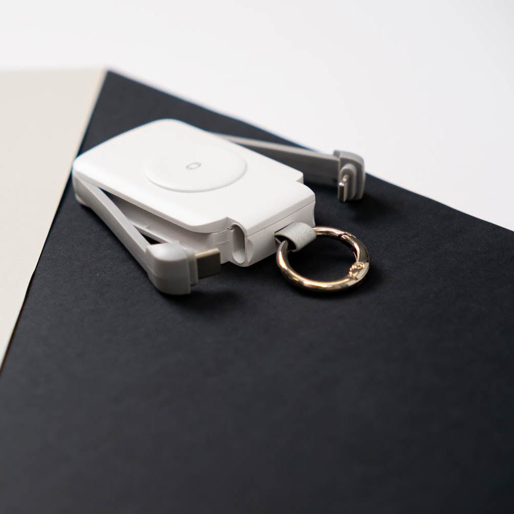 White PTC WatchGo 2000 with a gold keyring on a black backdrop
